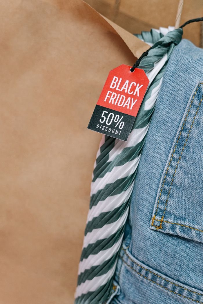footer-cta Close-up of Black Friday 50% discount tag on denim jeans, perfect for seasonal sales promotions.