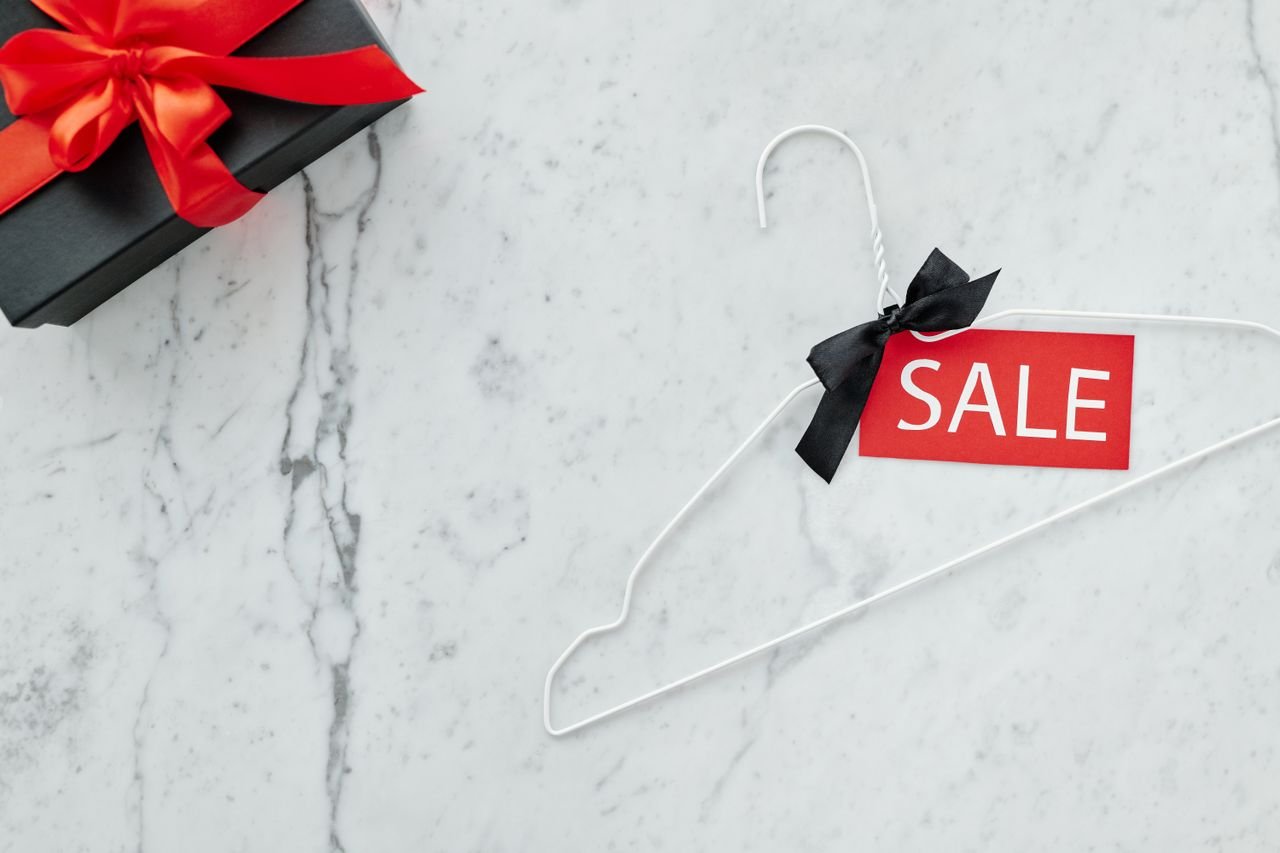 services-cta Flat lay of a sale tag on a hanger and gift box on marble, perfect for holiday promotions.